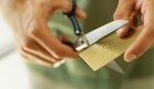 close-up of human hands cutting a credit card by scissors
