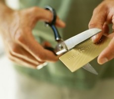 close-up of human hands cutting a credit card by scissors
